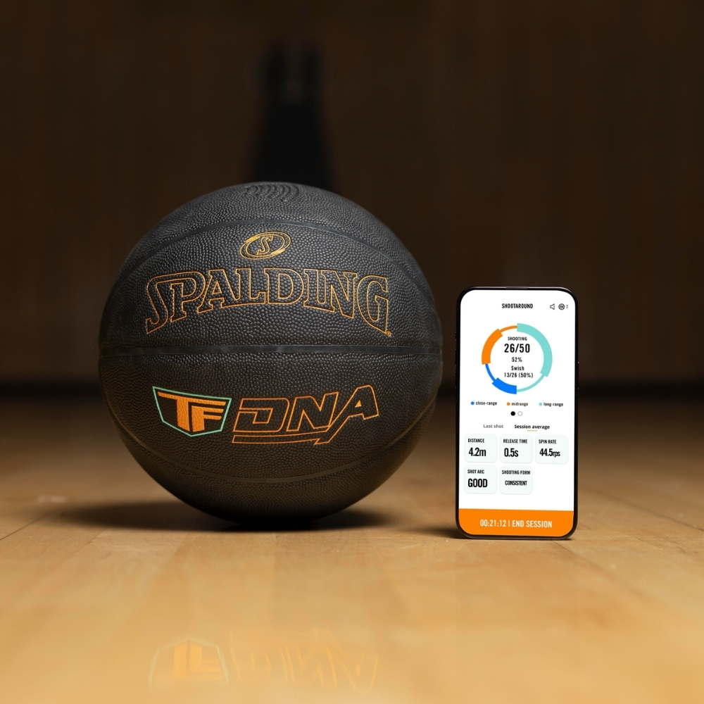 Layflat image of the Spalding TF DNA Smart Basketball next to a sleek black backpack, showcasing the complete training bundle. The premium basketball features advanced internal sensor technology designed to track shots and performance through the TF DNA app.